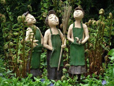 Billede af 3 syngene skulpturer i en have
